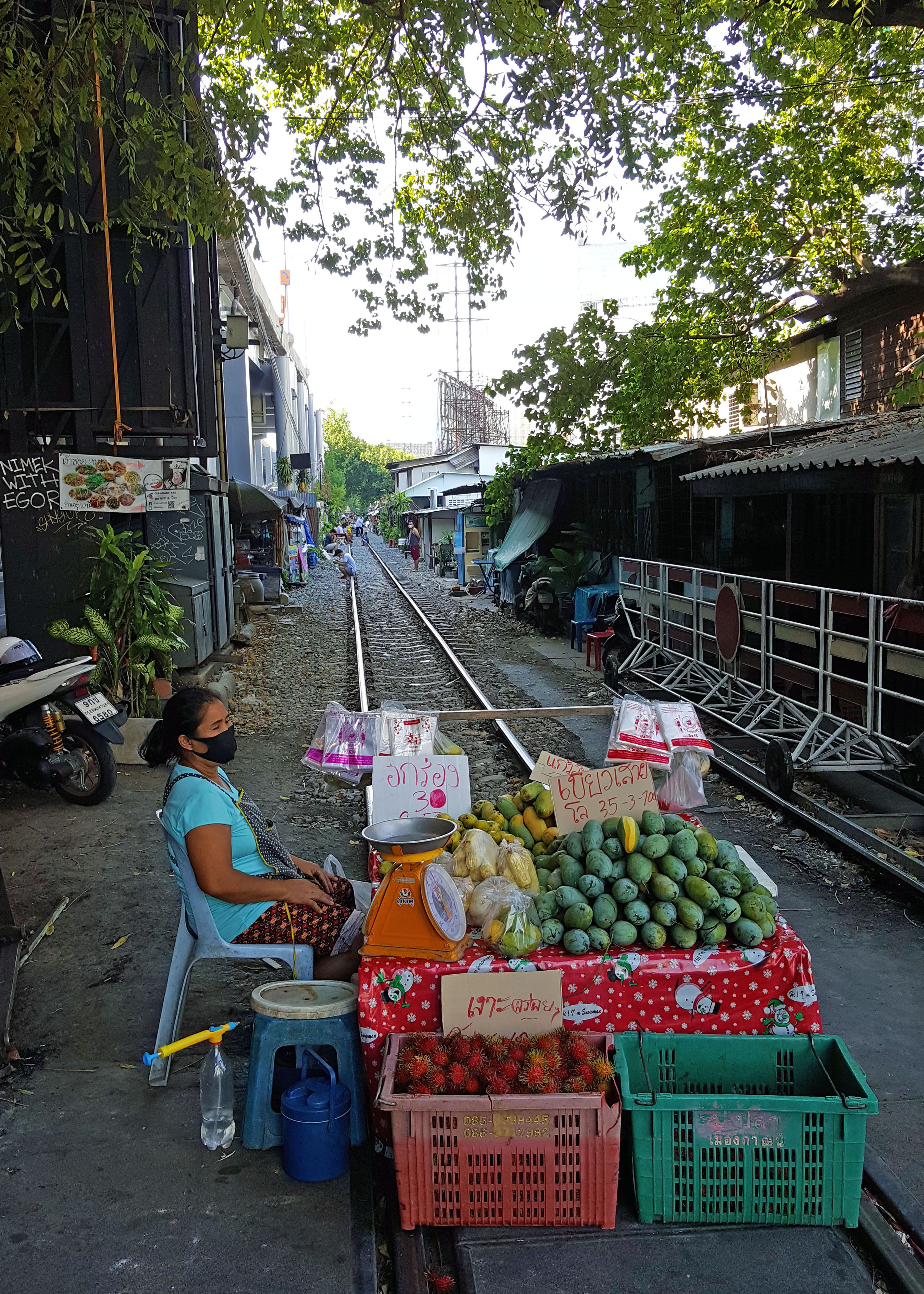 Woman selling fruits on closed traintrack